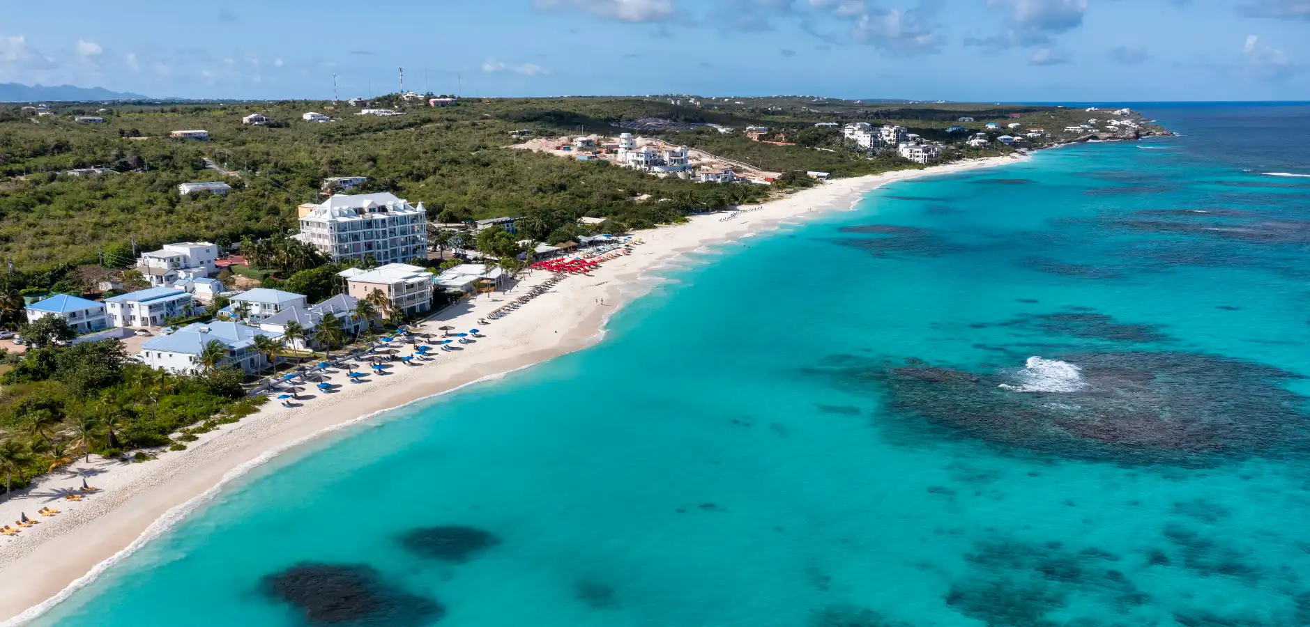 Open-deck speedboat racing across turquoise Caribbean water toward Anguilla